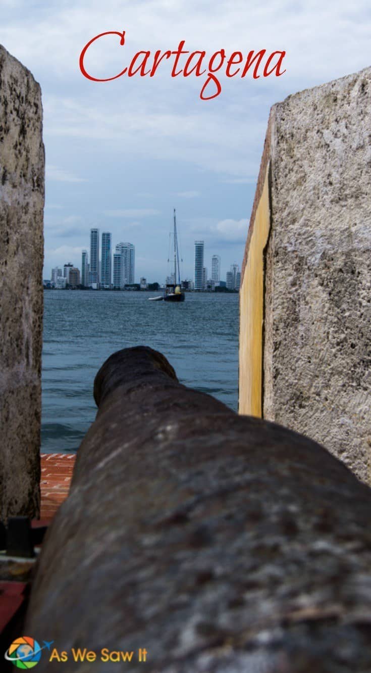 Here's why you'll love Cartagena, the jewel of Colombia’s cities. Image of cannon pointing across the bay with Cartagena skyscrapers in the background. Text overlay says Cartagena.