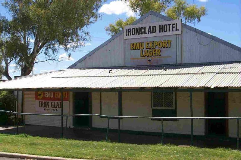 Buildilng with corrugated steel awning across the front. Sign at the peak says Ironclad Hotel. Sign underneath says Emu Export Lager.